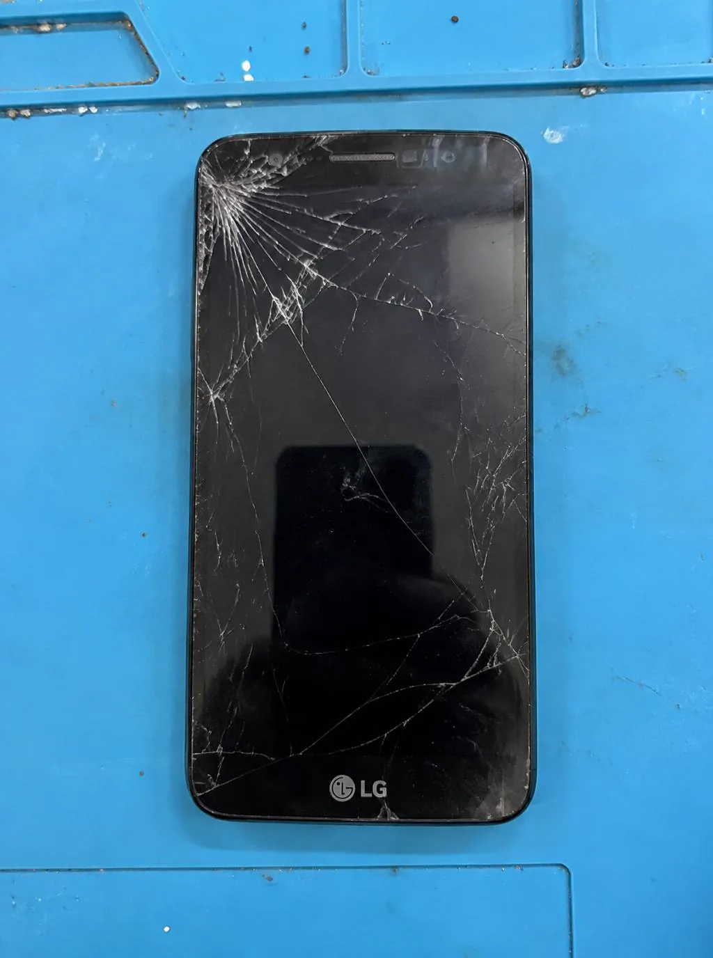 Celular LG com a tela trincada antes do reparo